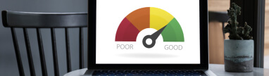 Laptop with gauge showing good credit score